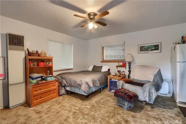 carpeted bedroom with ceiling fan, white fridge, and fridge