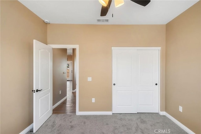 unfurnished bedroom with ceiling fan, a closet, and light carpet