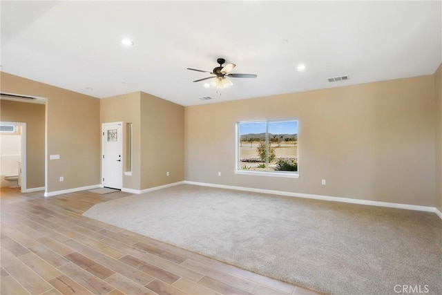 empty room featuring light wood-type flooring and ceiling fan