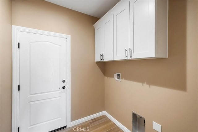 washroom featuring cabinets, hookup for a washing machine, and light hardwood / wood-style floors