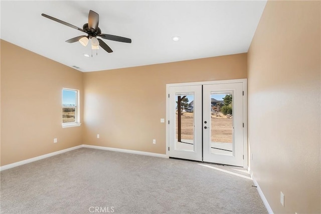 empty room featuring plenty of natural light, ceiling fan, light colored carpet, and french doors