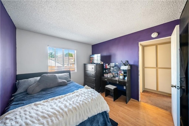 bedroom featuring wood-type flooring and a textured ceiling