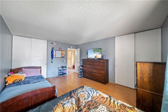 bedroom featuring a closet, wood-type flooring, and a textured ceiling