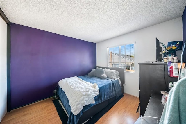 bedroom with hardwood / wood-style floors and a textured ceiling