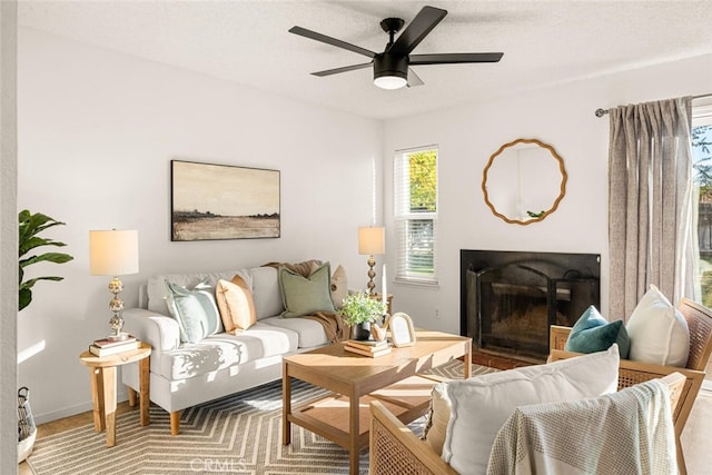 living room featuring ceiling fan and a textured ceiling