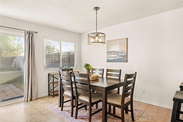 dining area featuring a textured ceiling and a chandelier