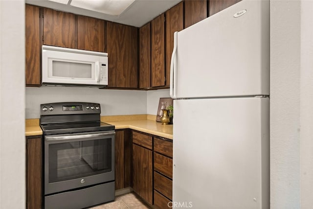 kitchen featuring white appliances and light tile patterned floors