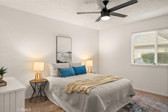 bedroom with ceiling fan, a textured ceiling, and carpet floors