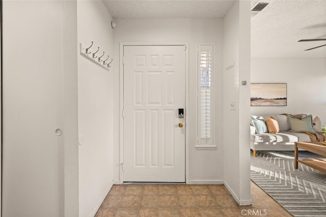 foyer entrance featuring ceiling fan and a textured ceiling