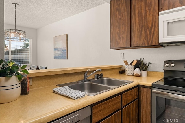 kitchen featuring sink, a textured ceiling, stainless steel electric range, and hanging light fixtures