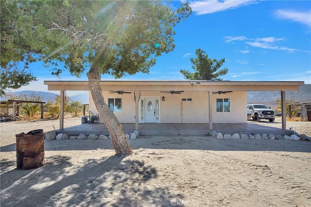 view of front of house featuring ceiling fan and a mountain view