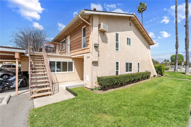 back of property with a wall unit AC and a yard