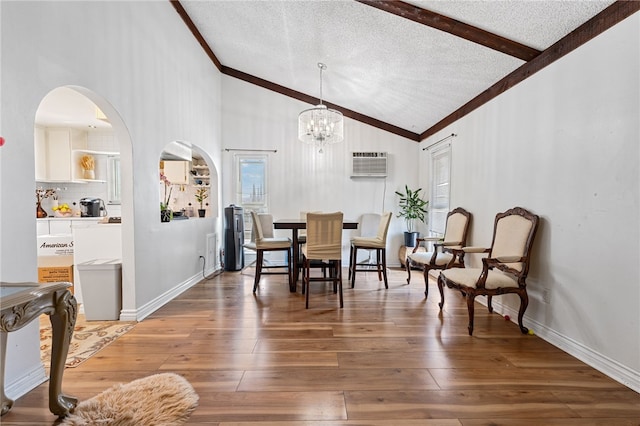 dining area featuring a notable chandelier, wood-type flooring, lofted ceiling with beams, and a textured ceiling