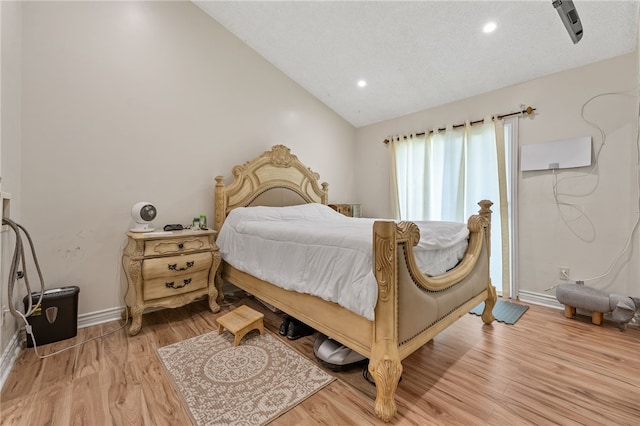 bedroom featuring light hardwood / wood-style floors and vaulted ceiling