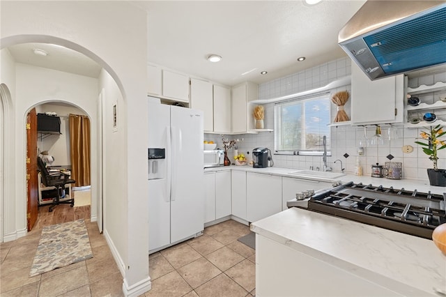 kitchen with white appliances, backsplash, white cabinets, ventilation hood, and sink