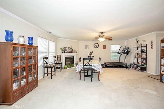 exercise room featuring ceiling fan, light colored carpet, and ornamental molding