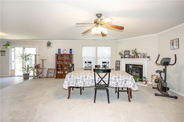 dining area featuring crown molding, ceiling fan, and light carpet