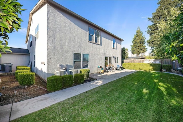 back of property with a yard and a patio