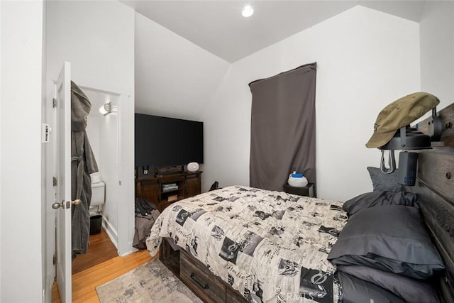 bedroom with lofted ceiling and light wood-type flooring