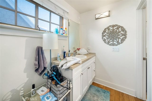 bathroom with vanity, baseboards, and wood finished floors