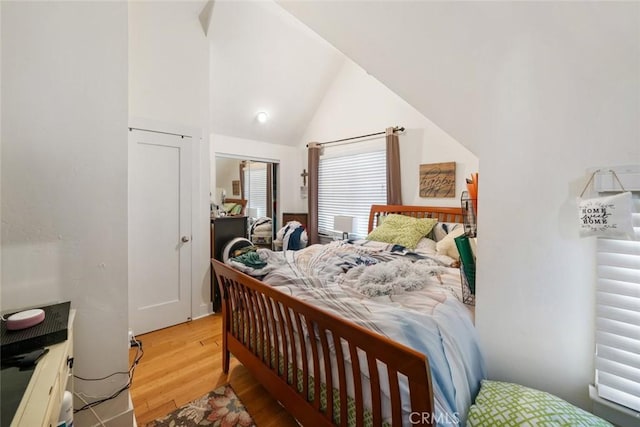 bedroom with vaulted ceiling and light hardwood / wood-style flooring