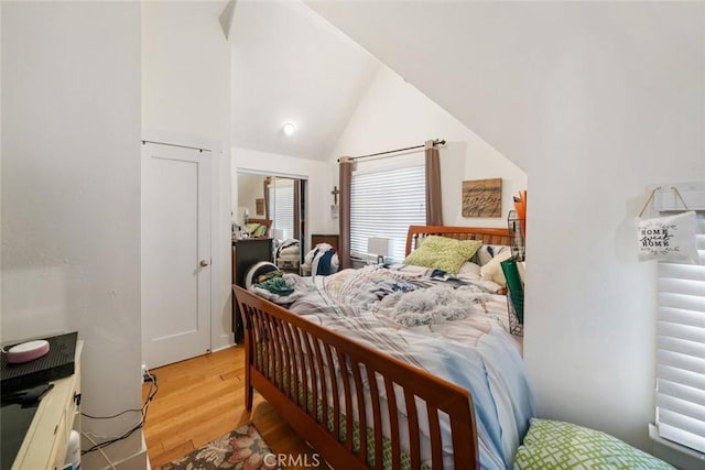 bedroom featuring vaulted ceiling and light wood finished floors