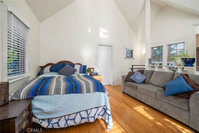 bedroom featuring high vaulted ceiling and wood finished floors