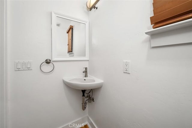 bathroom featuring a sink and baseboards