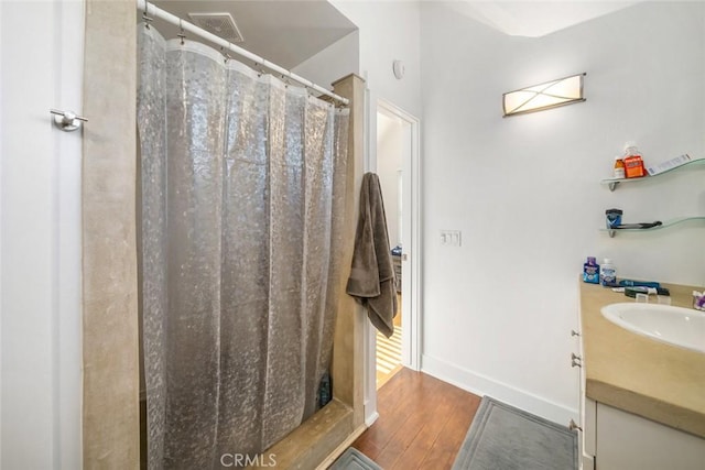 bathroom with vanity, wood-type flooring, and walk in shower