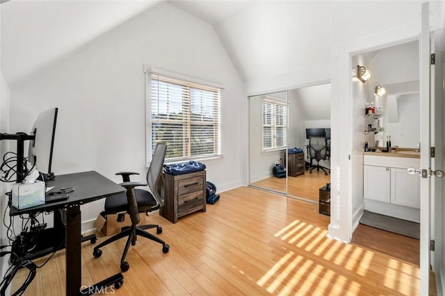 office area featuring light hardwood / wood-style flooring and vaulted ceiling