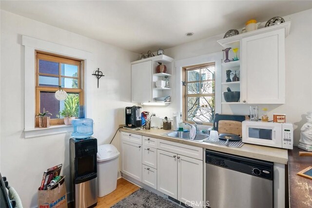 kitchen featuring dishwasher, white cabinets, light hardwood / wood-style flooring, and sink