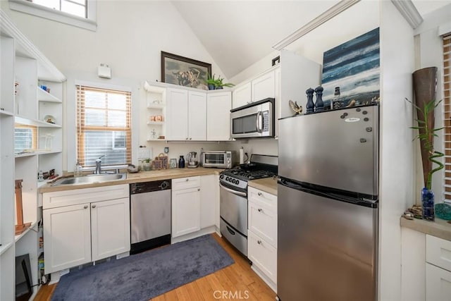 kitchen featuring sink, white cabinets, stainless steel appliances, and light hardwood / wood-style flooring