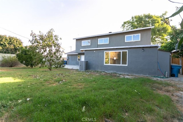 rear view of house featuring central AC and a yard