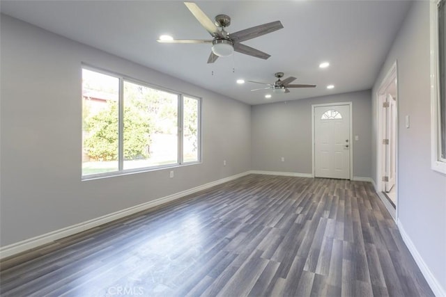 empty room featuring ceiling fan, dark hardwood / wood-style flooring, and a healthy amount of sunlight