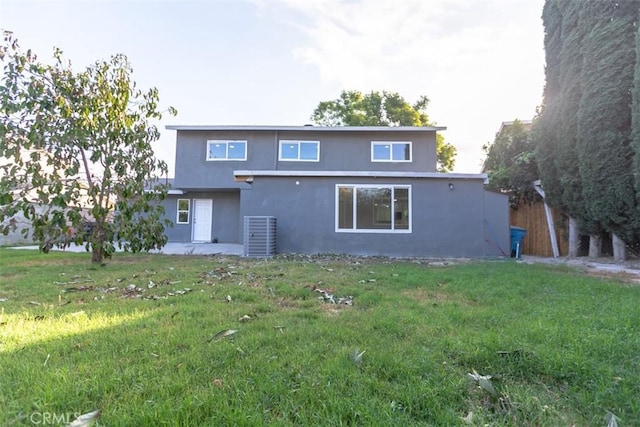 rear view of house with a yard and central AC unit