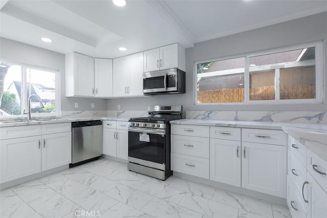 kitchen featuring crown molding, sink, light stone countertops, white cabinetry, and stainless steel appliances