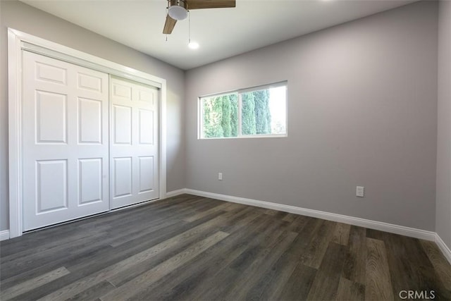 unfurnished bedroom featuring dark hardwood / wood-style floors, ceiling fan, and a closet