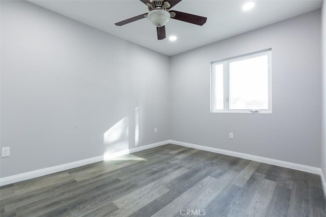 empty room with dark hardwood / wood-style floors and ceiling fan