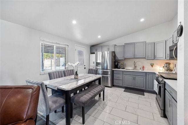 kitchen featuring gray cabinets, stainless steel appliances, and vaulted ceiling