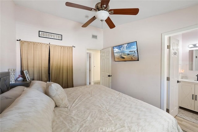 bedroom with light hardwood / wood-style flooring, ensuite bath, and ceiling fan