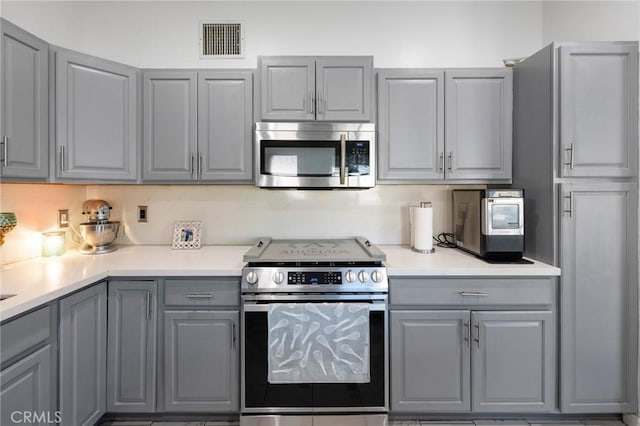 kitchen with gray cabinetry and stainless steel appliances