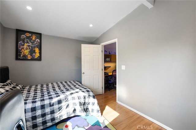 bedroom with hardwood / wood-style floors and vaulted ceiling