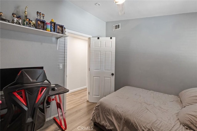 bedroom featuring ceiling fan, wood-type flooring, and vaulted ceiling