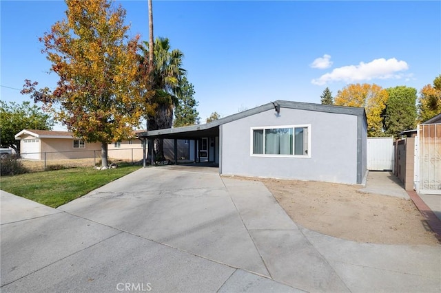 ranch-style home featuring a front lawn and a carport