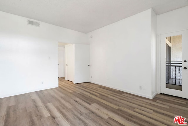 unfurnished room with hardwood / wood-style floors