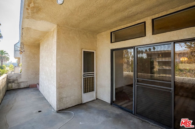 view of exterior entry with a balcony