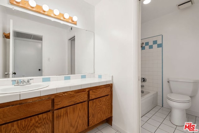 full bathroom featuring toilet, vanity, tile patterned floors, and tiled shower / bath combo