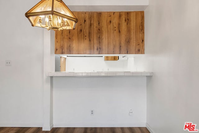 kitchen with a notable chandelier and dark hardwood / wood-style flooring