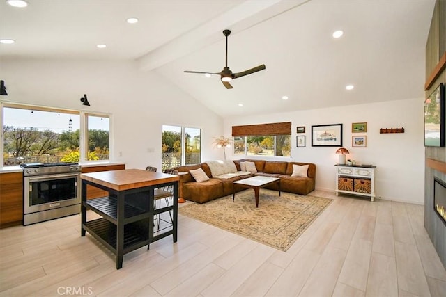 living room featuring ceiling fan, beam ceiling, high vaulted ceiling, and light hardwood / wood-style flooring