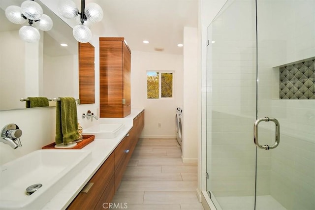 bathroom with hardwood / wood-style floors, vanity, washer / clothes dryer, and an enclosed shower